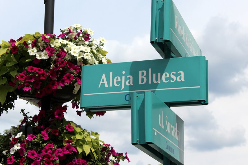 6 kolejnych osób z tabliczkami w białostockiej Alei Bluesa